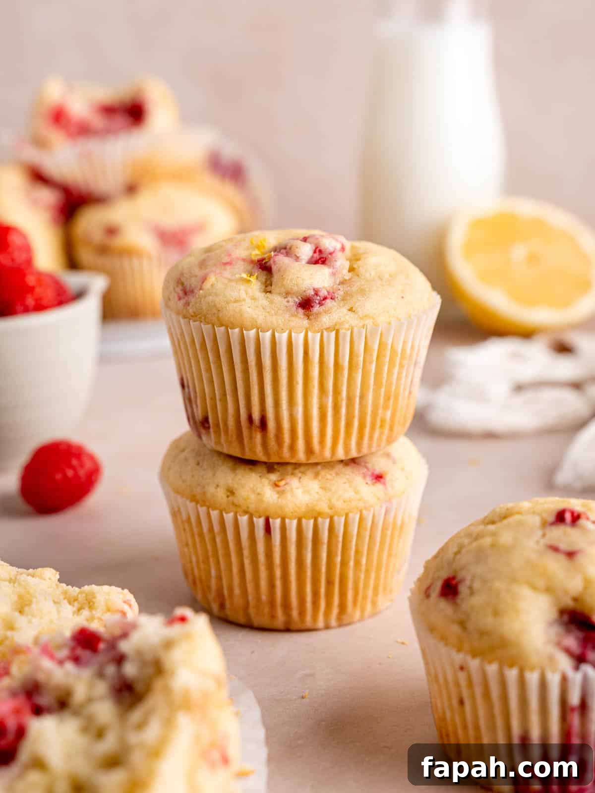 Lemon Raspberry Muffins with Zesty Glaze 2 Lemon raspberry muffins stacked on top of each other.