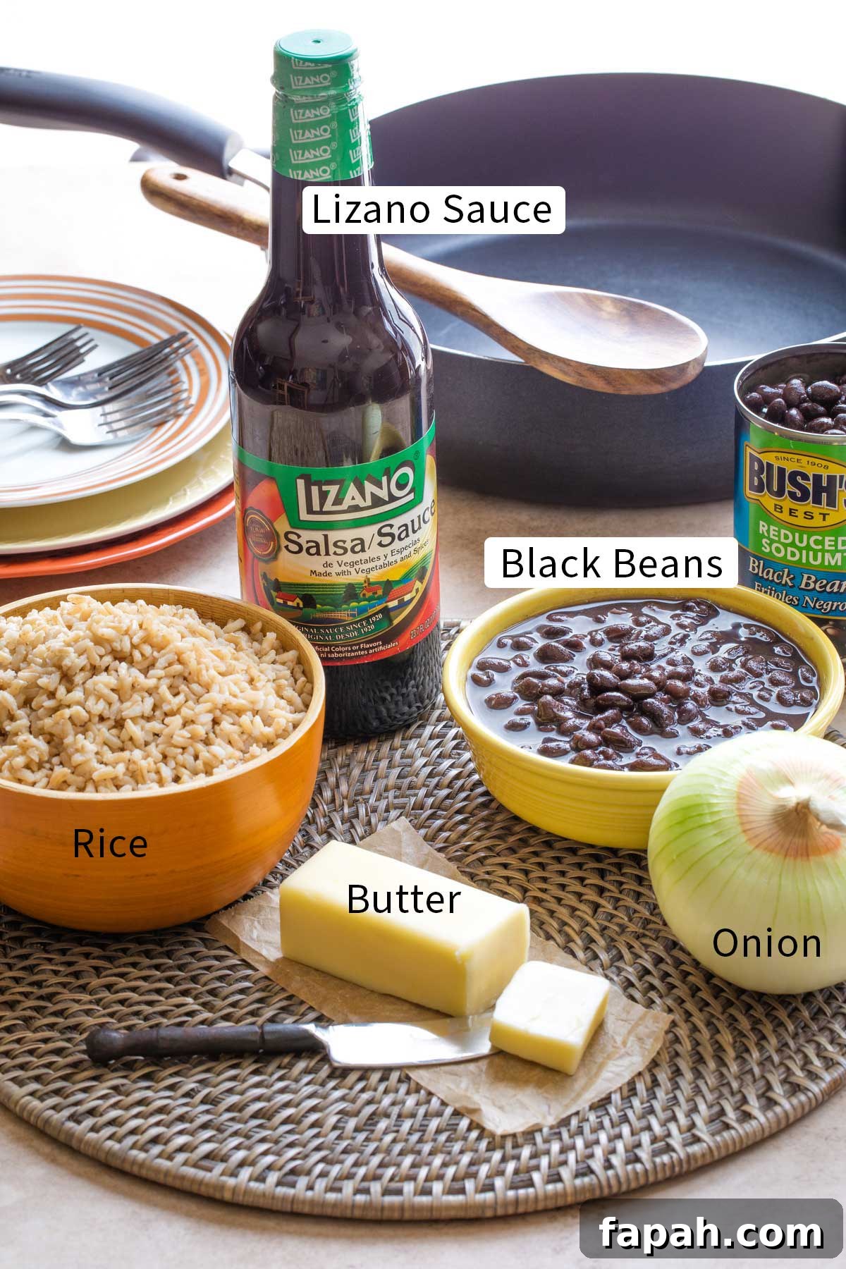 Labeled photo of recipe ingredients with text overlays "Lizano Sauce", "Rice", "Black Beans", "Butter" and "Onion".