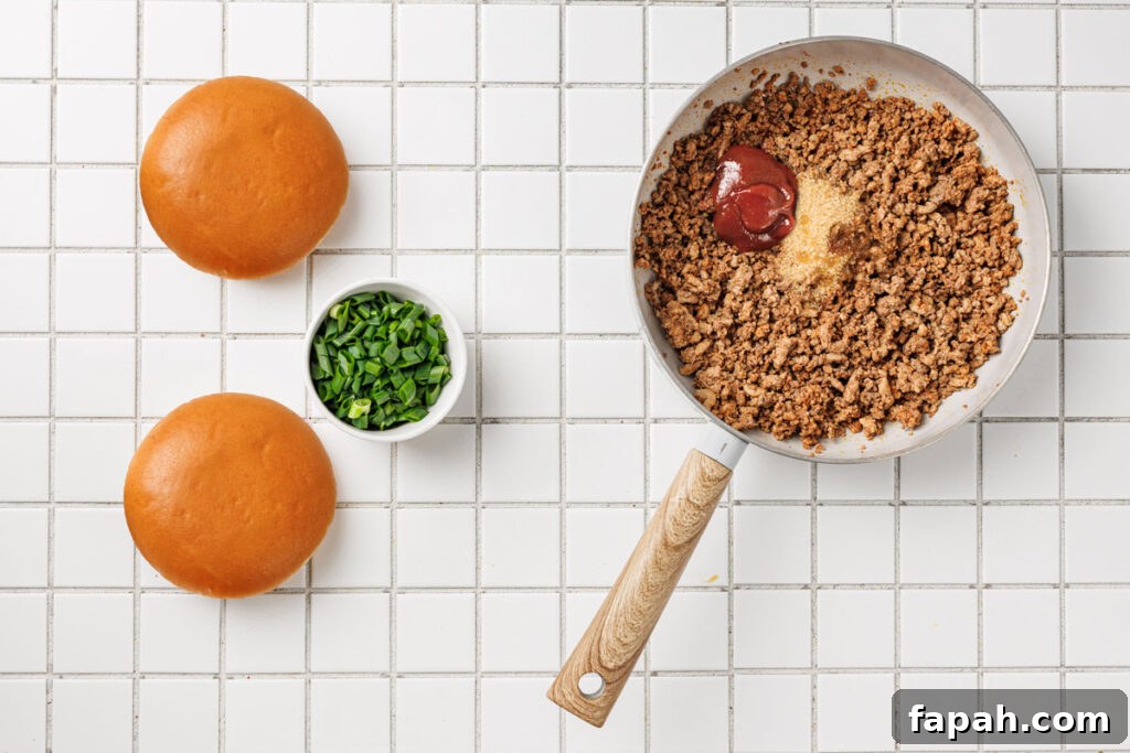pan with korean sloppy joes in it with bun and toppings nearby