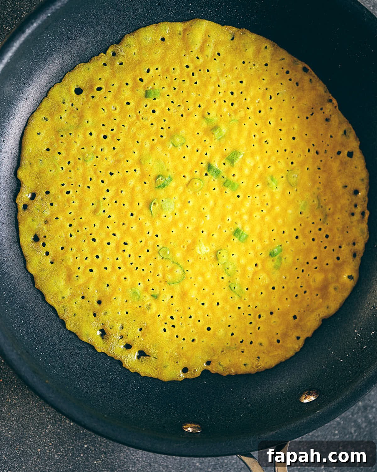 Crispy Banh Xeo Vietnamese Pancakes: How to Make Authentic Crepes 3 Vietnamese crepe being cooked in a non stick pan