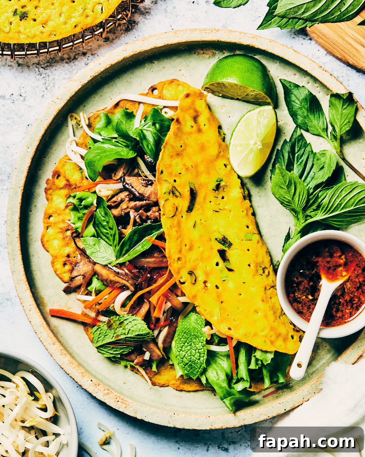 Crispy Banh Xeo Vietnamese Pancakes: How to Make Authentic Crepes 4 Folded crispy Vietnamese crepe with drizzling sauce and lime