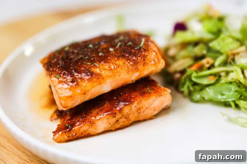 Sweet and Spicy Salmon in the Air Fryer: Quick Crispy Recipe 3 A white serving plate with two fillets of sweet and spicy air fryer salmon. salmon air fryer time.