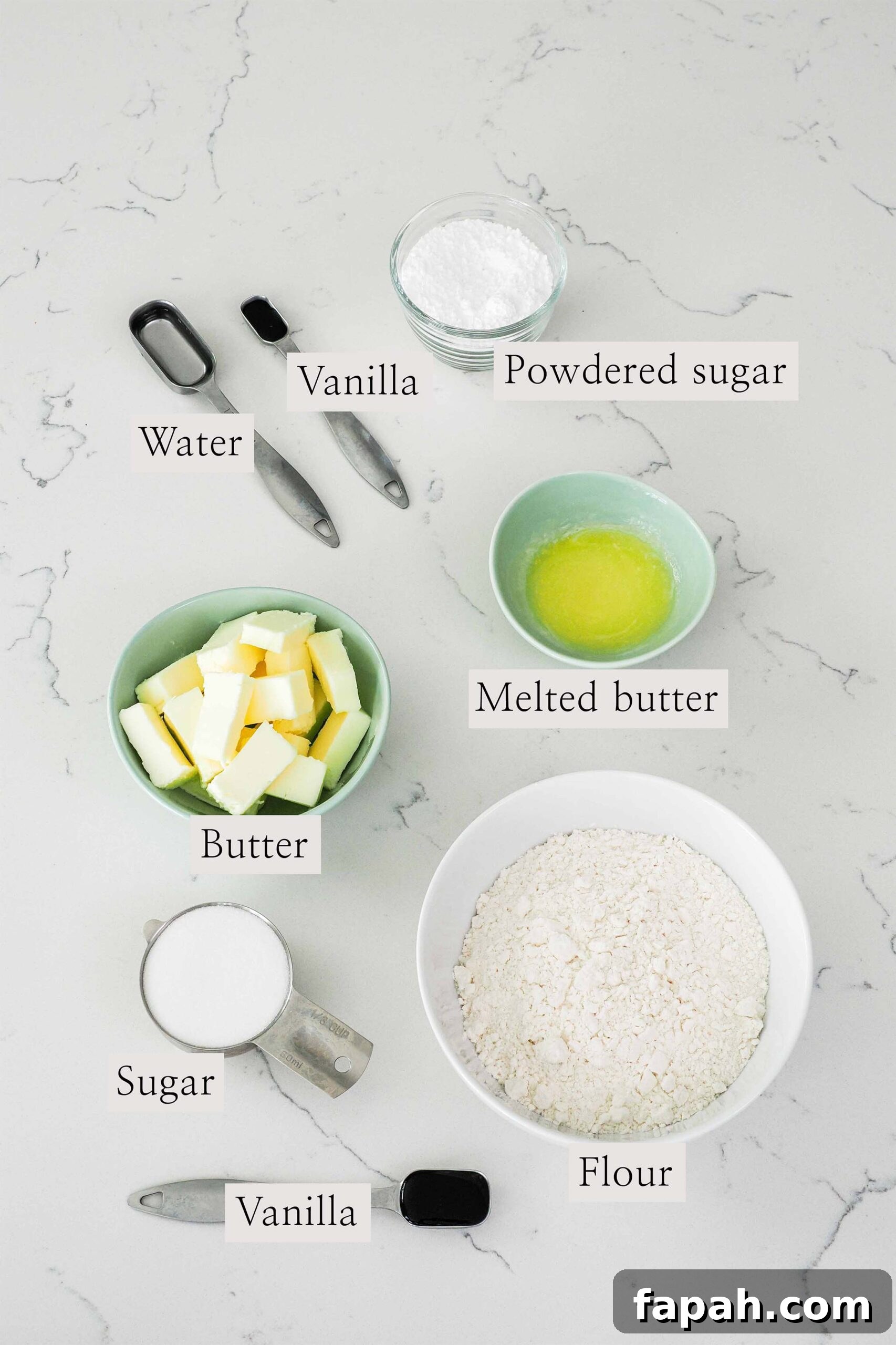 Ingredients needed to make vanilla shortbread cookies on a quartz counter.