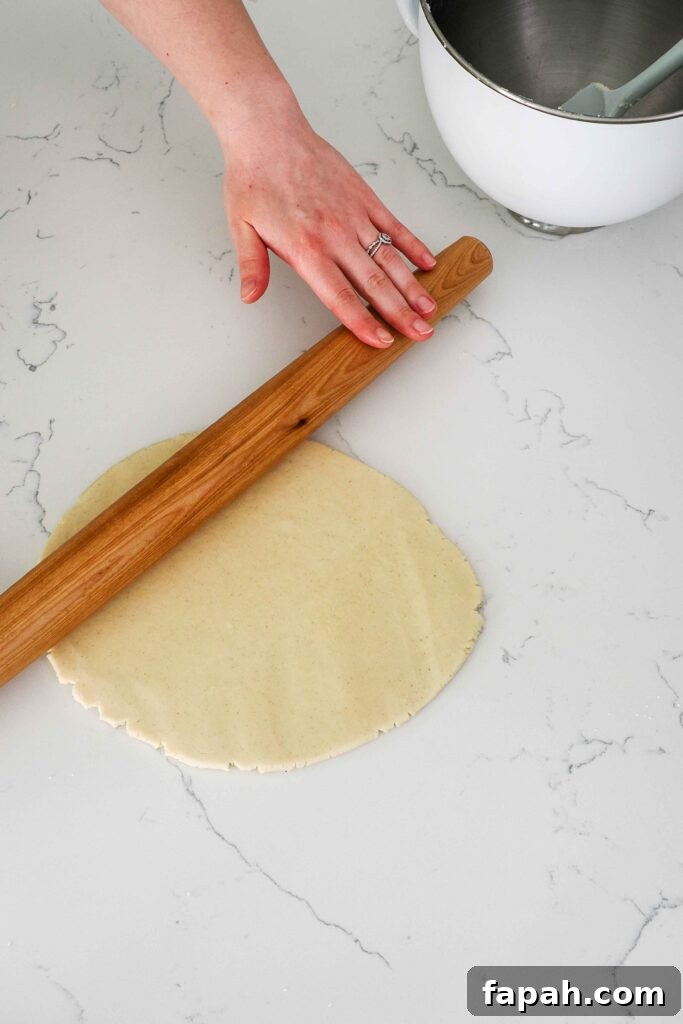 Shortbread dough is rolled out on a quartz counter.