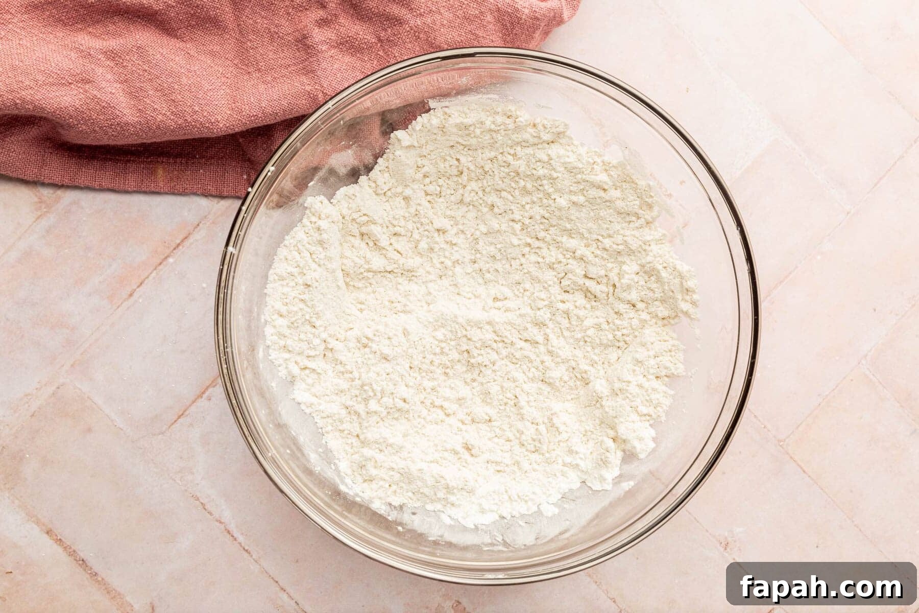 A glass mixing bowl with a gluten-free flour blend mixture in it.