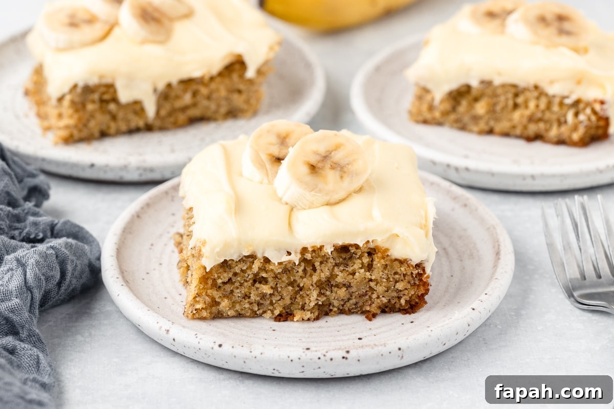 Slices of banana cake with cream cheese frosting in 3 saucer plates.