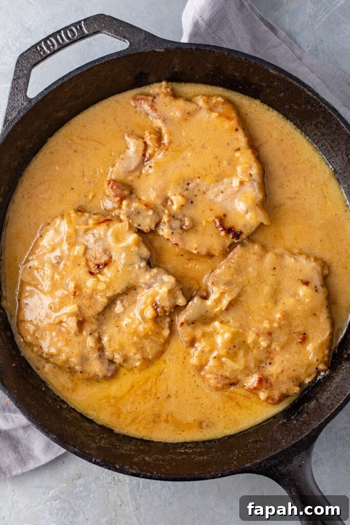 southern smothered pork chops in a cast iron skillet 