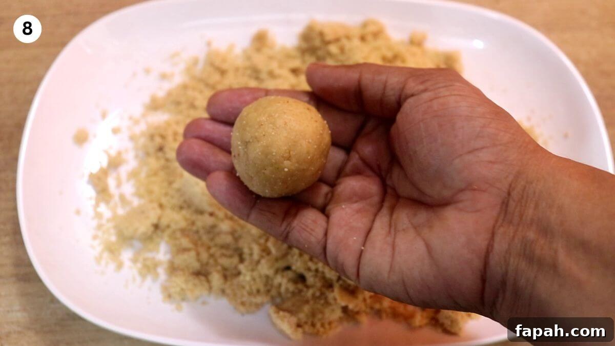 peanut jaggery ladoo held in hands.