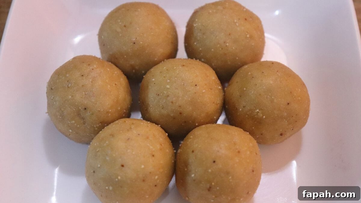Peanut jaggery ladoos arranged on a white plate.