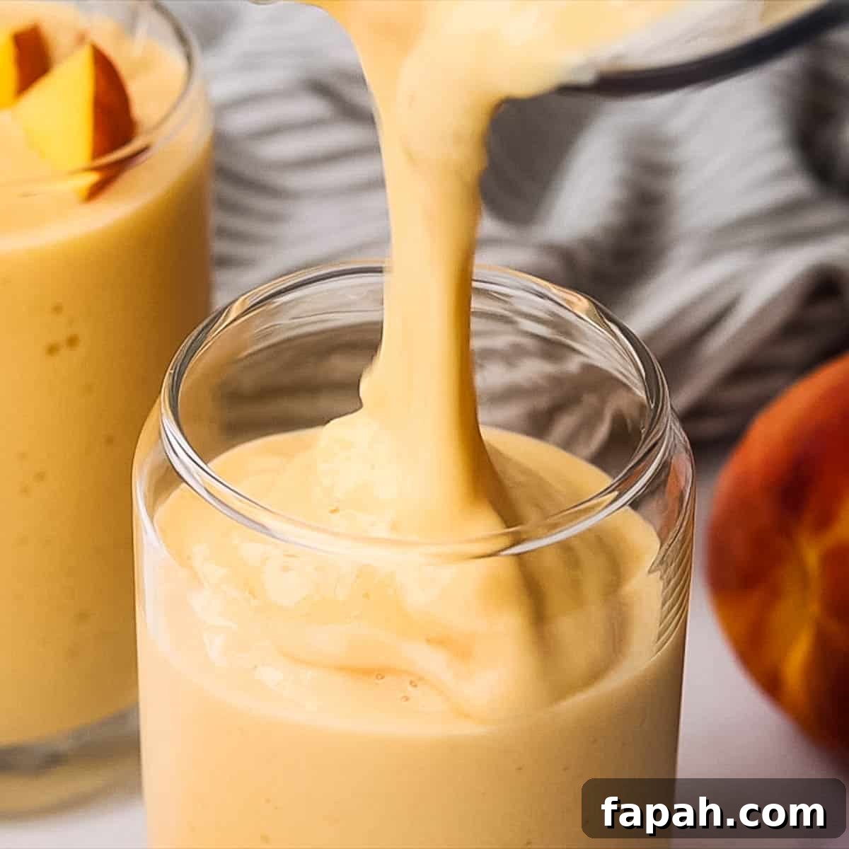 Creamy Peach Banana Smoothie Recipe for Refreshing Mornings 7 Pouring smoothie in a glass.