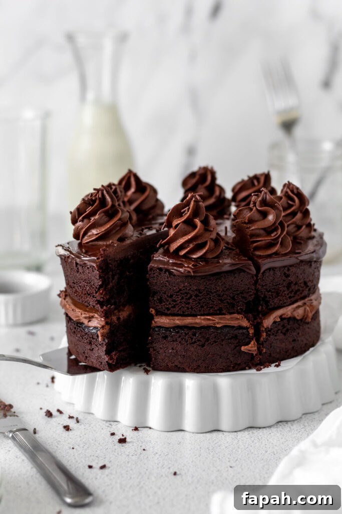 Decadent Chocolate Ganache Cake Recipe with Glossy Finish 3 Chocolate cake cut into slices on a white pan.
