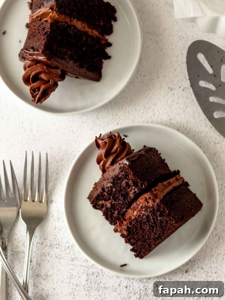 Decadent Chocolate Ganache Cake Recipe with Glossy Finish 4 Slices of chocolate cake on small white plates with forks and a spatula nearby.