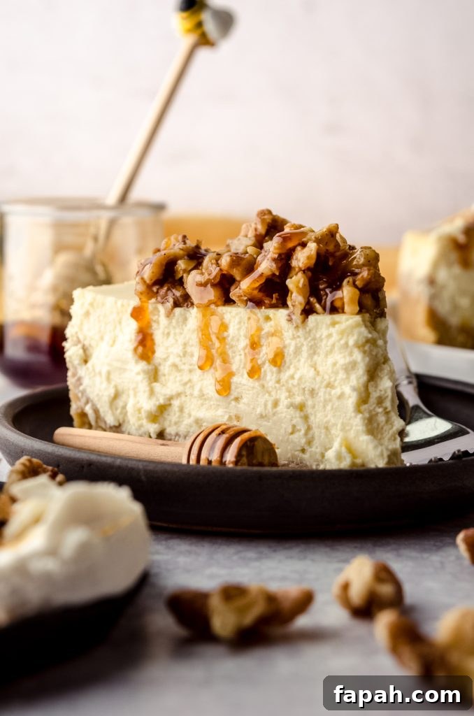 Goat Cheese Cheesecake with Roasted Honey Walnut Topping 3 A slice of goat cheese cheesecake with honey walnut topping dripping down the side.