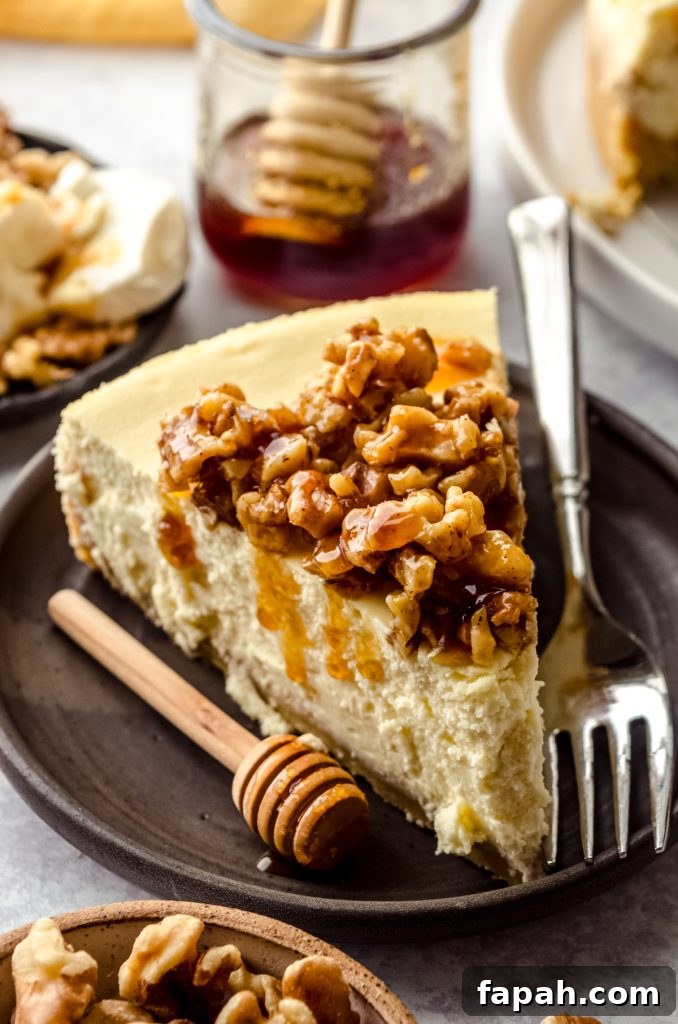 Goat Cheese Cheesecake with Roasted Honey Walnut Topping 4 A plated slice of goat cheese cheesecake with honey walnut topping and a fork.