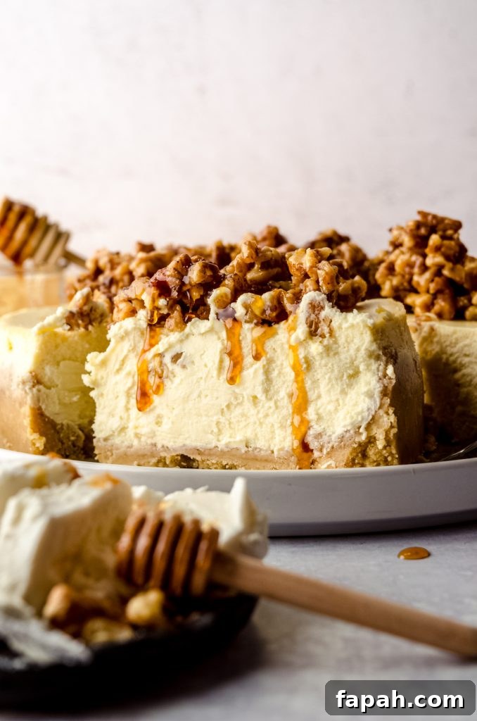 Goat Cheese Cheesecake with Roasted Honey Walnut Topping 6 A slice of goat cheese cheesecake on a platter with honey walnut topping dripping down the side.