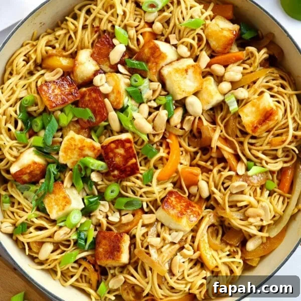 Satay-style peanut butter noodles with halloumi in a big pan.