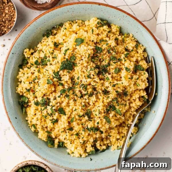 A bowl filled with cous cous and a fork.