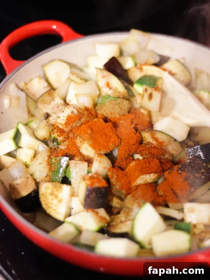 Chopped vgetables and spices in a pan, ready to cook Mediterranean Halloumi Bake.