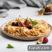 Folded French crepes topped with fresh fruit on a grey plate.