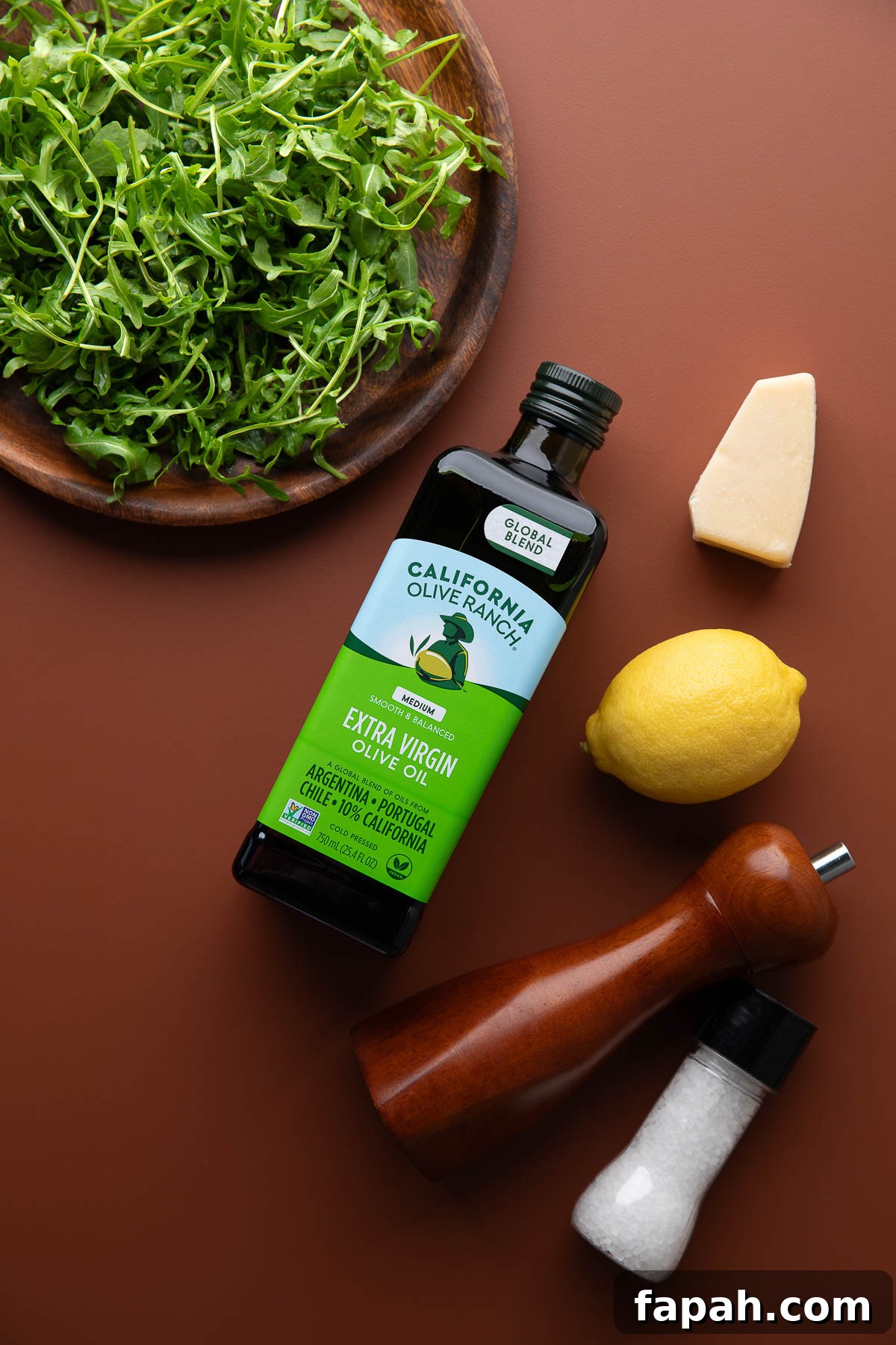 ingredients for arugula salad: arugula, olive oil, parmesan, lemon, salt and pepper