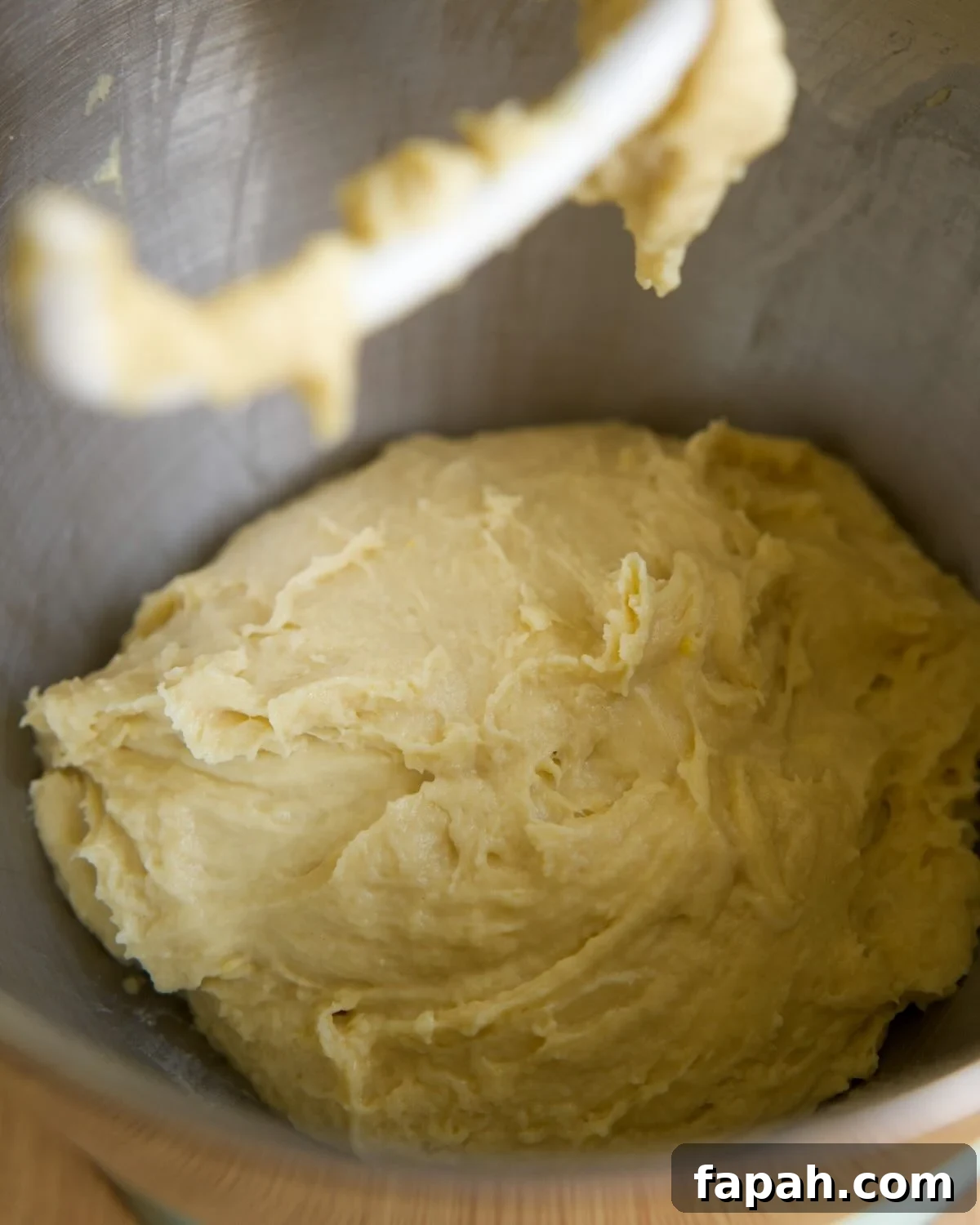 dough has come together in a mixing bowl, with sides scraped down