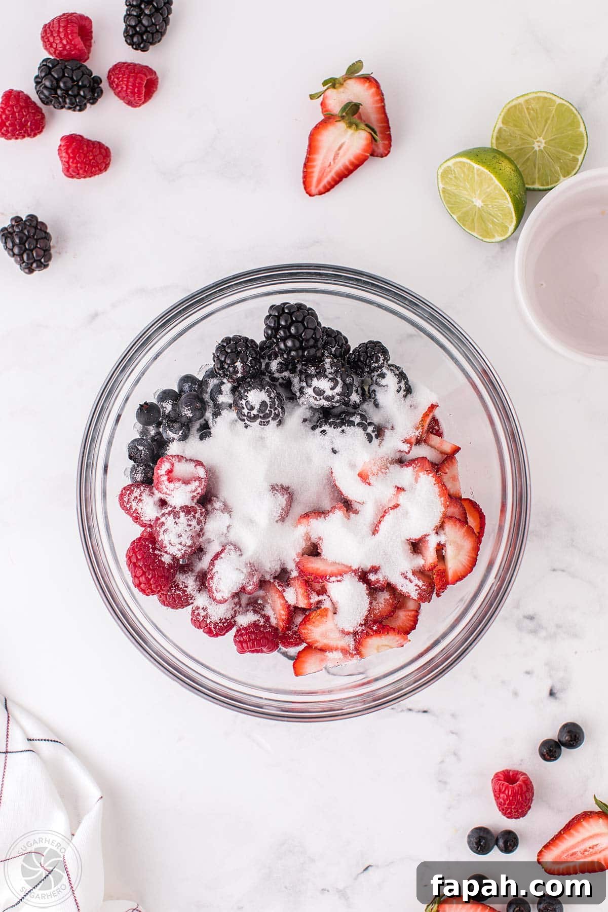 A bowl of mixed berries covered with sugar.