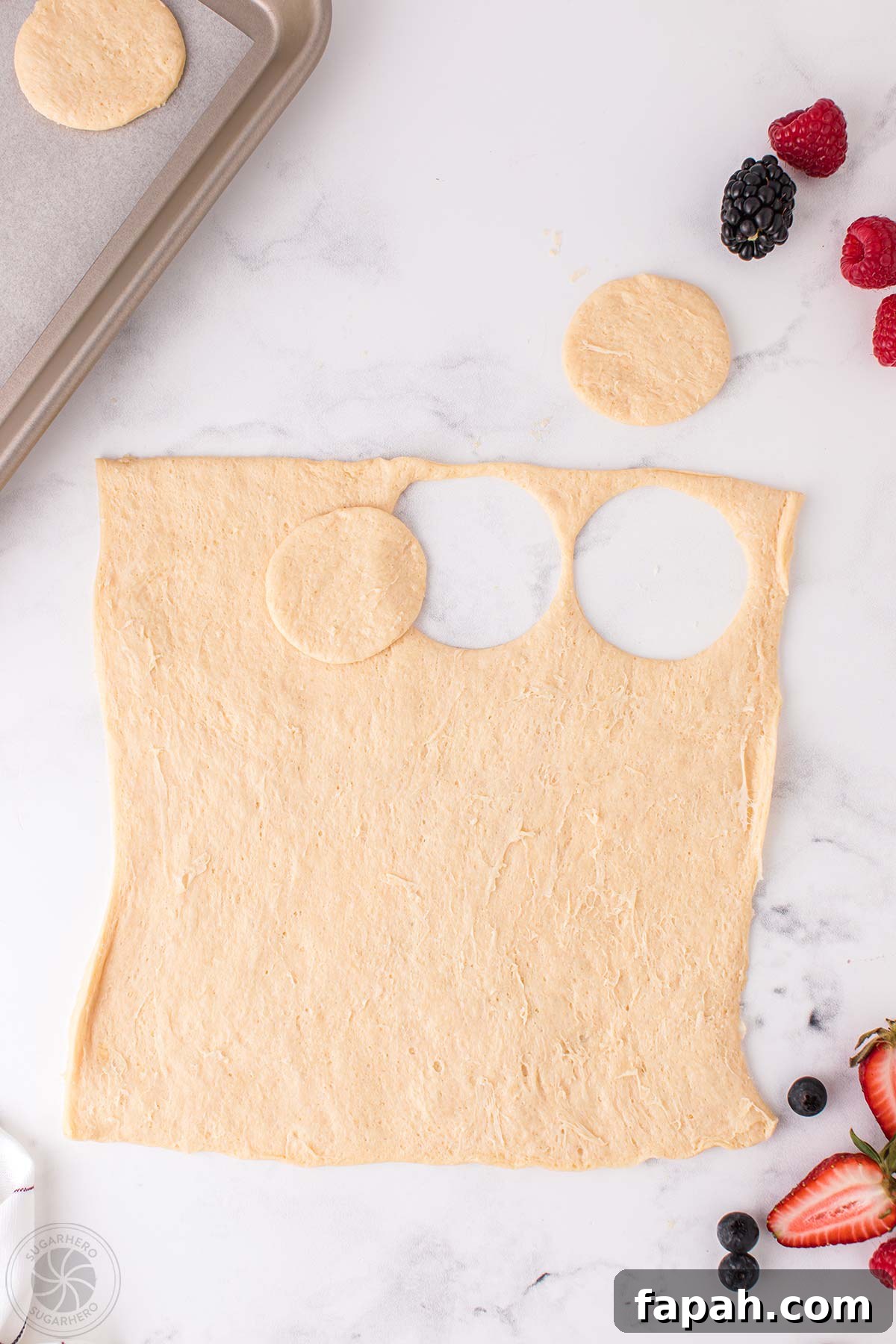Crescent dough with circles cut out of it.