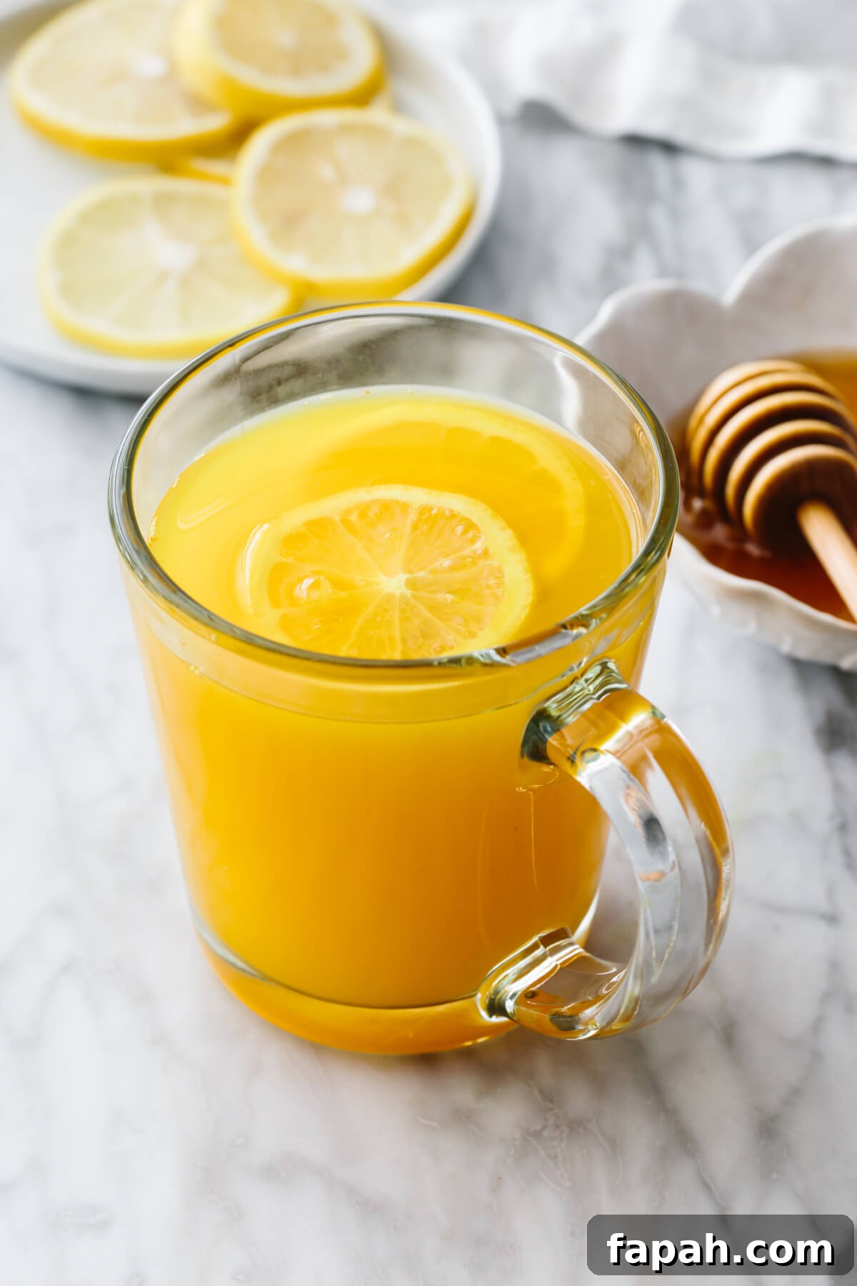 Turmeric tea in a glass with lemon slices.