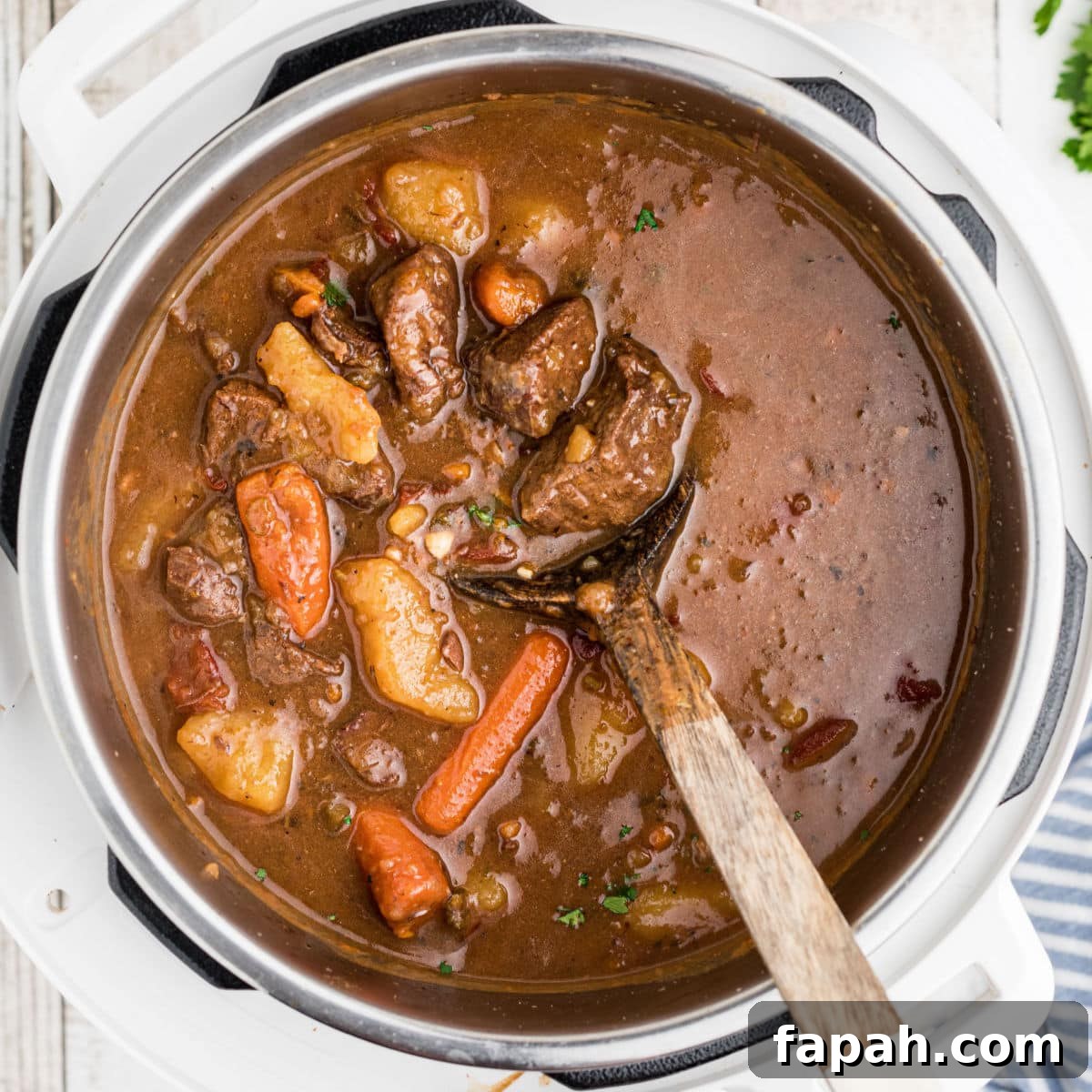 An instant pot venison stew with a spoon digging in.