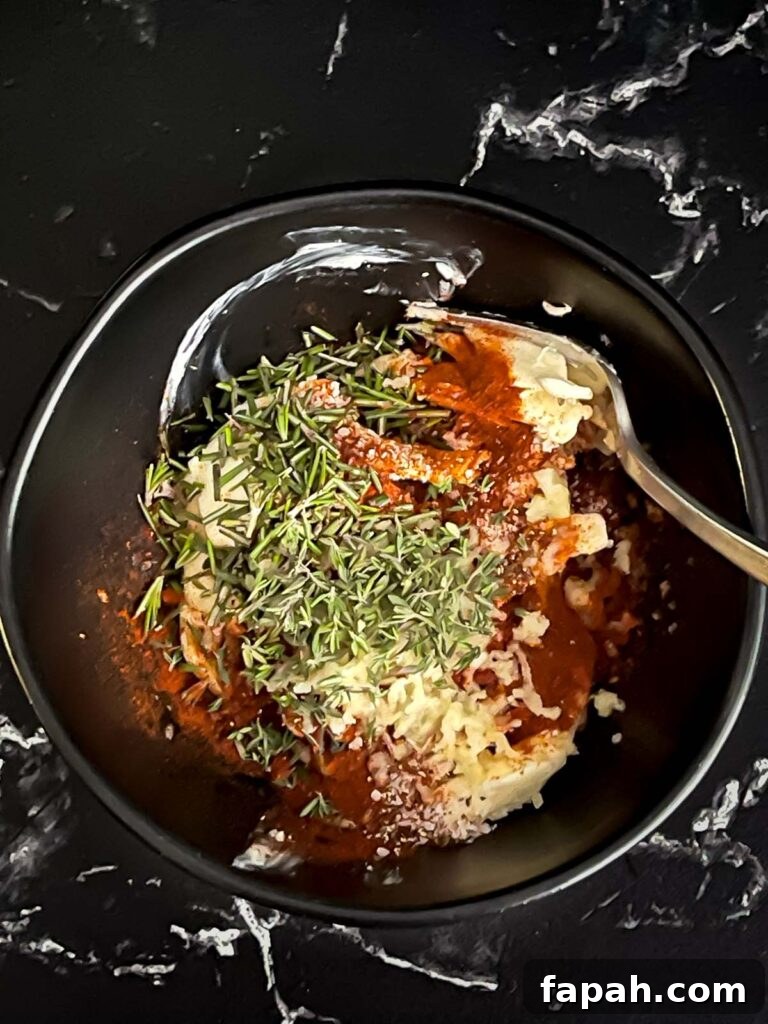 Compound butter ingredients in a dark bowl on a dark surface.