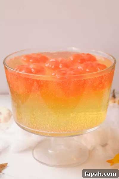 Molded Halloween pumpkin ice cubes floating in yellow non-alcoholic punch
