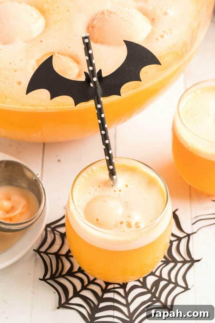 Glasses and punch bowl with spider web doily and Halloween-themed straw