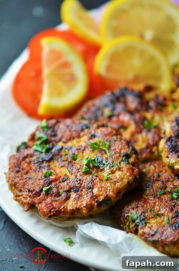 chicken chapli kabab on a white plate garnished with cilantro